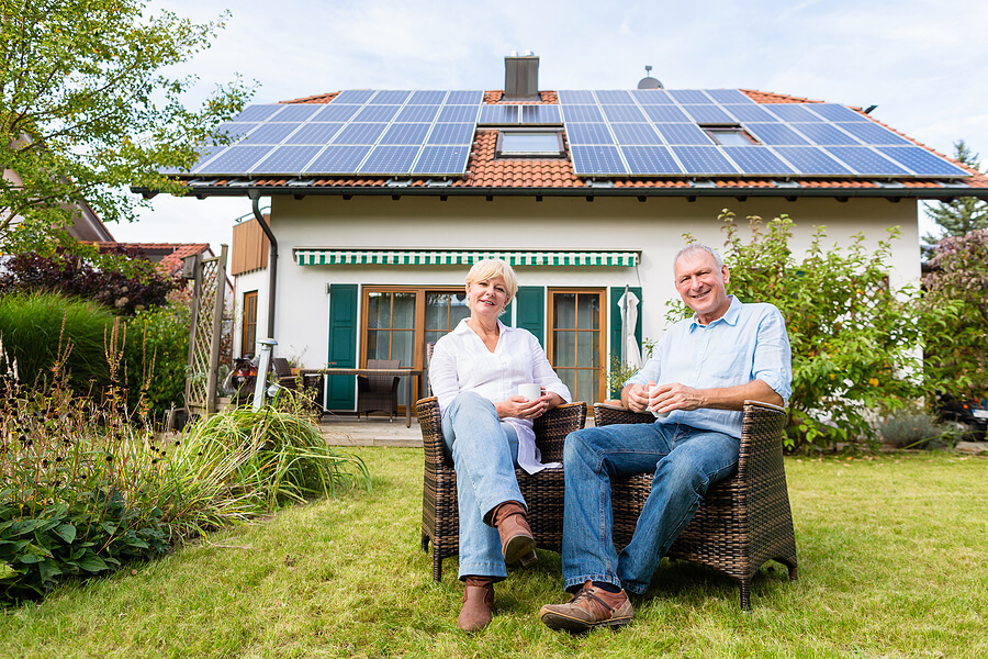 Senior couple sitting on wicker chairs in backyard of their home