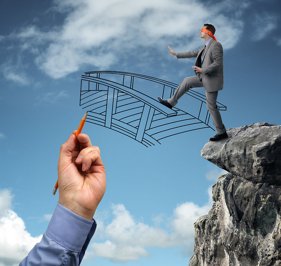 Man stepping off a cliff but a bridge is being built to prevent him from falling